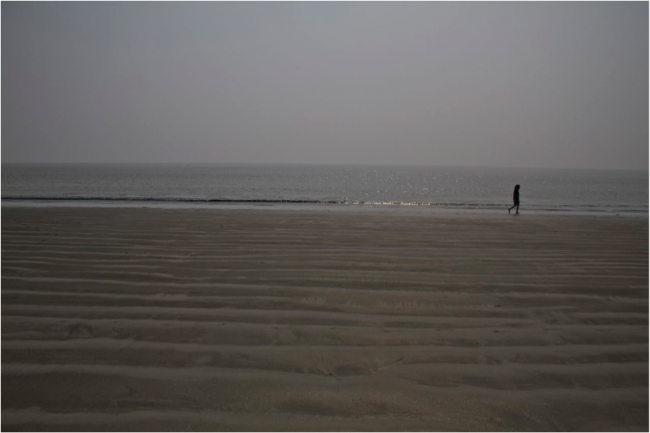 Jan walks along rippled sands by the Bay of Bengal